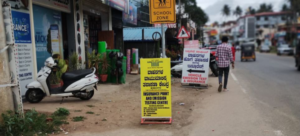 ಕುಶಾಲನಗರದಲ್ಲಿ ಪಾದಾಚಾರಿ ರಸ್ತೆಯನ್ನು ನುಂಗುತ್ತಿರುವ ಅಂಗಡಿ ಫಲಕಗಳು.